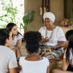 Mestra de cultura tradicional compartilhando conhecimentos com estudantes em uma atividade educativa comunitária